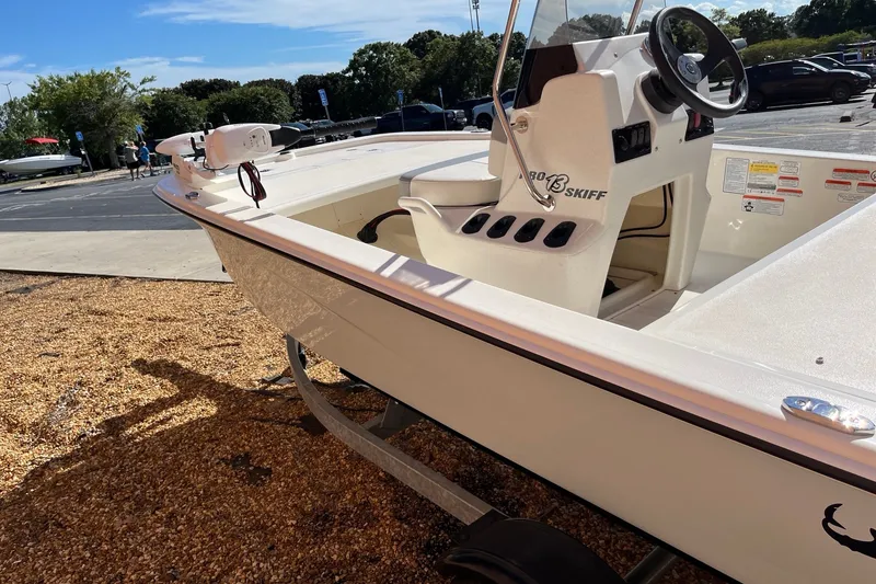 Slide: The Image of 2025 Mako Pro Skiff 13 CC boat displayed outdoors on gravel surface. - 2