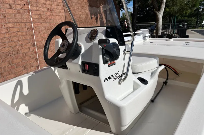 Slide: The Image of 2025 Mako Pro Skiff 13 CC boat interior with steering console and seating. - 5