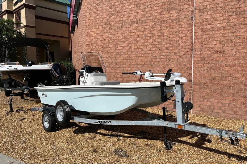 The Image of 2025 Mako Pro Skiff 13 CC boat on trailer, parked outdoors against brick wall. - 0