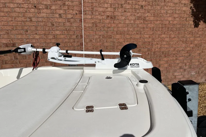 Slide: The Image of 2025 Mako Pro Skiff 13 CC with Minn Kota Maxxum trolling motor, parked by brick wall. - 8