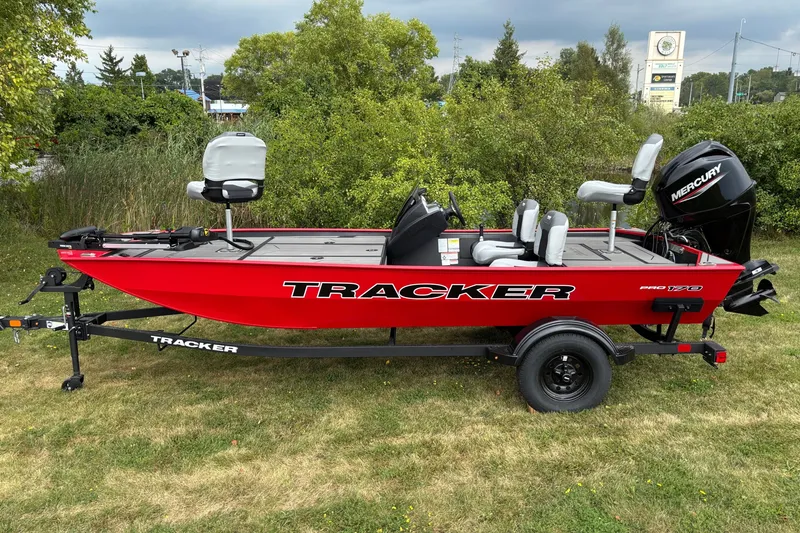 The Image of 2027 Tracker Pro 170 boat on trailer, red exterior, Mercury engine, parked on grass. - 0
