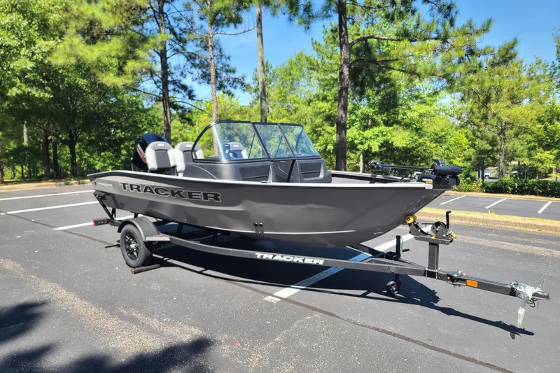 The Image of 2027 Tracker Pro Guide V-16 WT boat on trailer in sunny parking lot. - 0