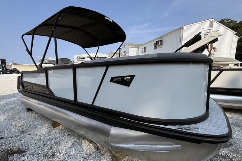 The Image of 2027 Alera A20L pontoon boat with canopy, displayed outdoors on gravel. - 0
