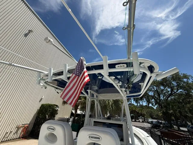 Slide: The Image of A 2020 Contender 28 Sport boat with an American flag, parked beside a building. - 22