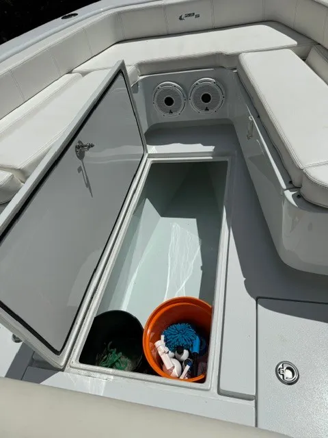 Slide: The Image of The image shows the storage compartment of a 2020 Contender 28 Sport boat with cleaning supplies. - 12