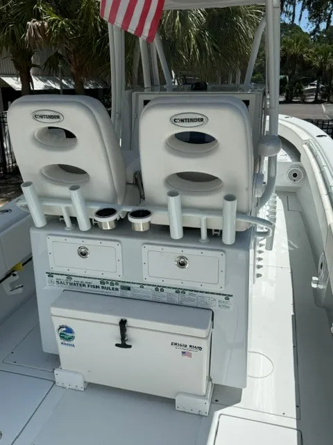 Slide: The Image of The image shows the cockpit of a 2020 Contender 28 Sport boat with rod holders and storage. - 6