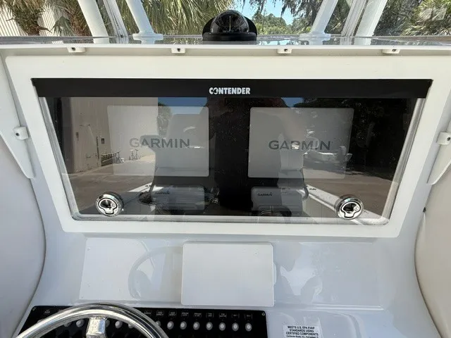 Slide: The Image of The image shows the dashboard of a Contender 28 Sport boat with two Garmin screens. - 15