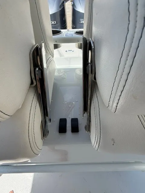 Slide: The Image of Two white cushioned boat seats with stainless steel brackets, two outboard motors visible behind. - 18