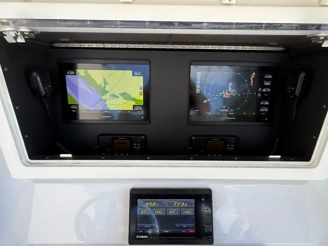 Slide: The Image of The image shows the dashboard of a 2020 Contender 28 Sport boat with navigation screens. - 14