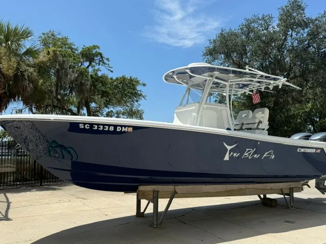 The Image of A 2020 Contender 28 Sport boat on a trailer, surrounded by trees. - 0