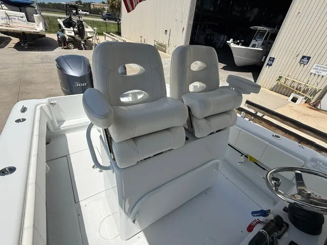 Slide: The Image of Two cushioned captain's chairs on a 2020 Contender 28 Sport boat, parked in a marina area. - 17