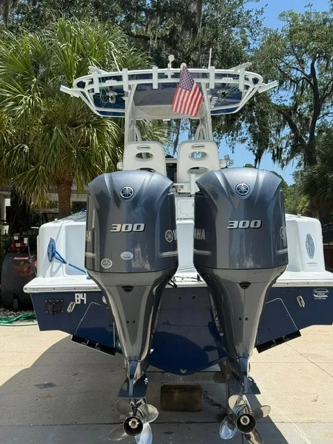 Slide: The Image of A 2020 Contender 28 Sport with twin Yamaha 300 engines, parked in a sunny area. - 2