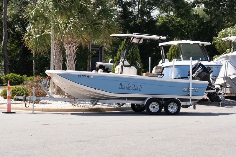 The Image of 2023 Carolina Skiff 21 Ultra Elite boat on trailer, parked near palm trees. - 1