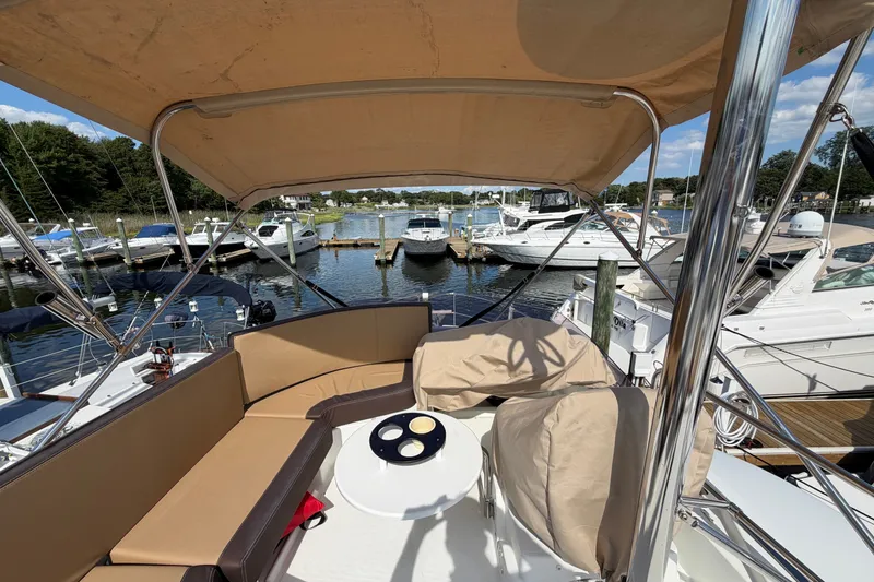 Slide: The Image of 2017 Beneteau Swift Trawler 30 with covered seating area, docked at a marina. - 50
