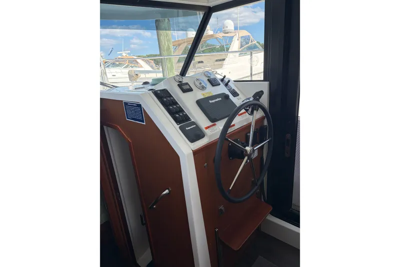 Slide: The Image of Helm of 2017 Beneteau Swift Trawler 30 with steering wheel and navigation controls. - 44
