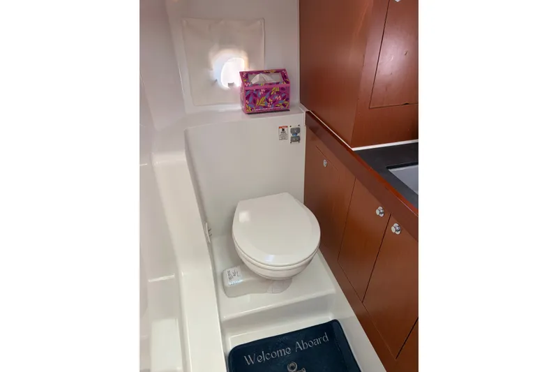 Slide: The Image of Bathroom interior of 2017 Beneteau Swift Trawler 30 with wooden cabinetry and nautical decor. - 34