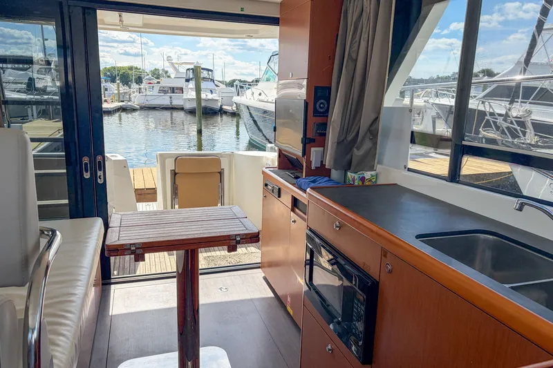 Slide: The Image of Interior of 2017 Beneteau Swift Trawler 30 with kitchen and marina view. - 60