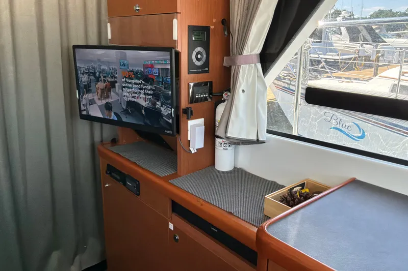 Slide: The Image of Interior of 2017 Beneteau Swift Trawler 30 with TV, window view, and wooden cabinetry. - 21