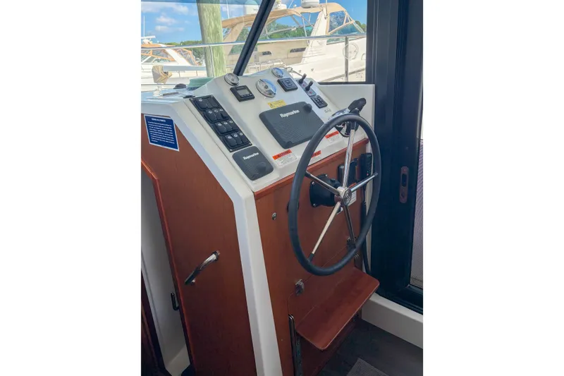 Slide: The Image of Helm of 2017 Beneteau Swift Trawler 30 with steering wheel and navigation controls. - 57