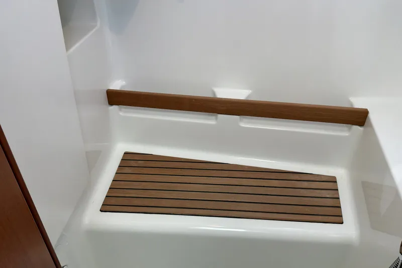 Slide: The Image of 2017 Beneteau Swift Trawler 30 shower area with wooden floor mat and seat. - 25
