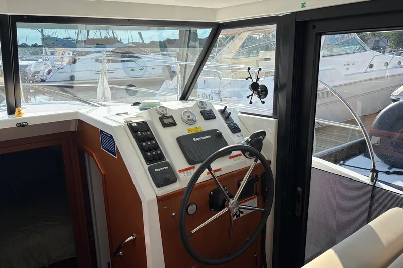 Slide: The Image of Helm of 2017 Beneteau Swift Trawler 30 with steering wheel and navigation controls. - 32