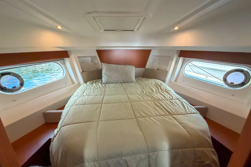 Slide: The Image of Cozy cabin interior of 2017 Beneteau Swift Trawler 30 with comfortable bed and porthole views. - 53