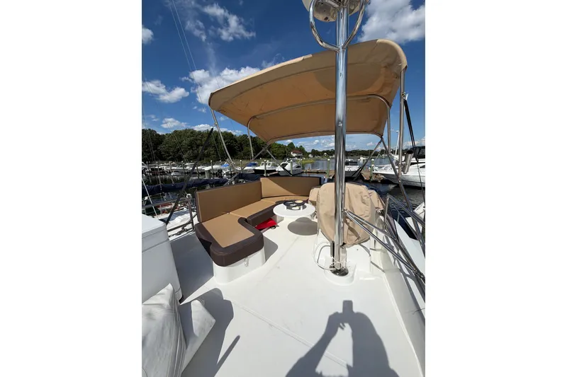 Slide: The Image of 2017 Beneteau Swift Trawler 30 flybridge with seating, canopy, and marina view. - 49