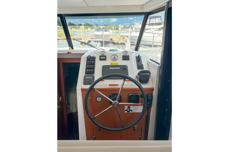 Slide: The Image of 2017 Beneteau Swift Trawler 30 helm with steering wheel and navigation controls. - 58