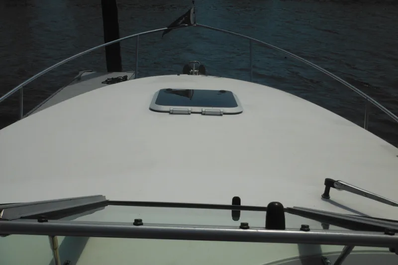Slide: The Image of 2005 Rinker Fiesta Vee 250 boat deck with hatch, docked on calm water. - 46