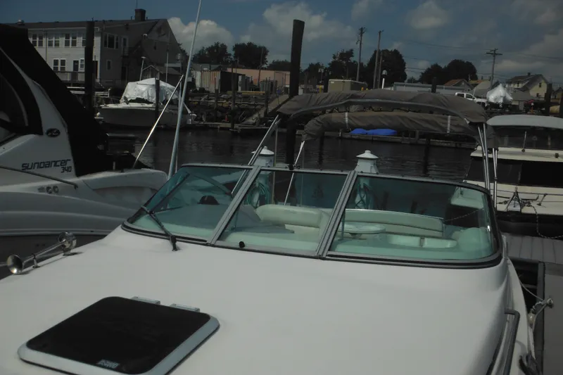Slide: The Image of 2005 Rinker Fiesta Vee 250 boat docked at marina under cloudy sky. - 57