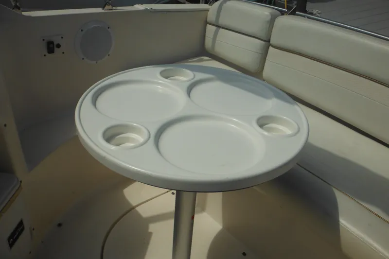 Slide: The Image of 2005 Rinker Fiesta Vee 250 boat interior with round table and cushioned seating. - 47