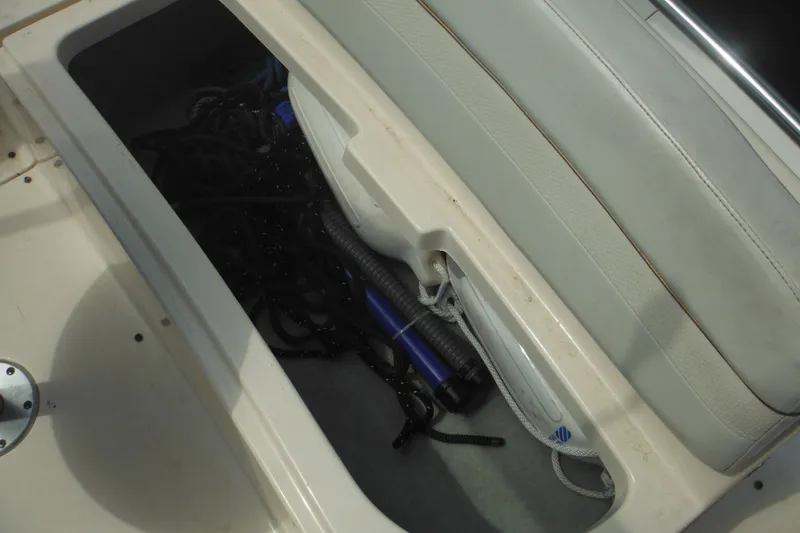 Slide: The Image of Storage compartment on a 2005 Rinker Fiesta Vee 250 boat with ropes and equipment. - 52