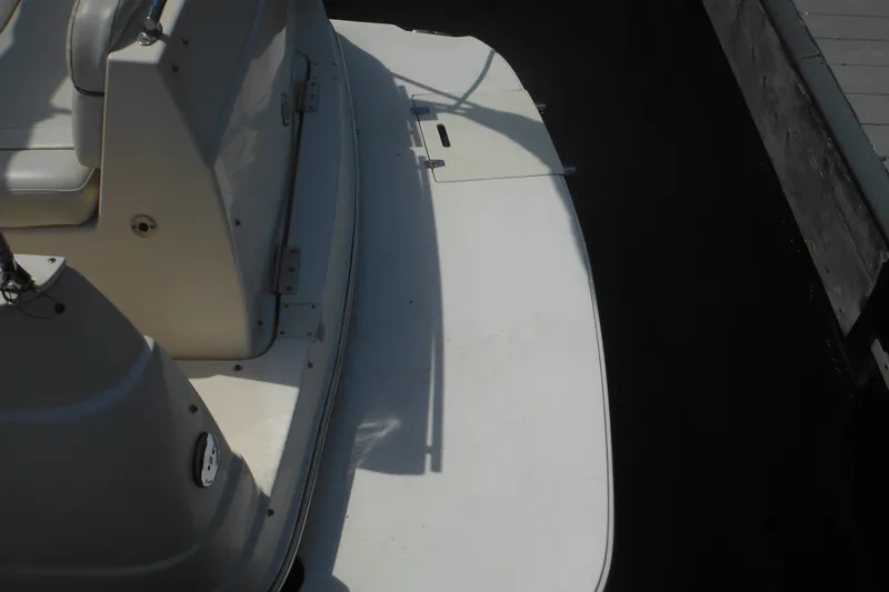 Slide: The Image of 2005 Rinker Fiesta Vee 250 boat deck near dock, showcasing seating and swim platform. - 14
