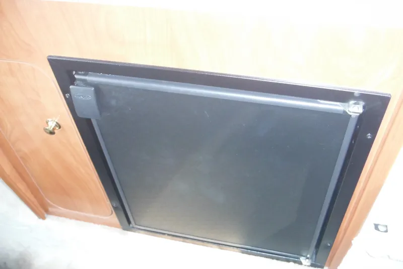 Slide: The Image of 2005 Rinker Fiesta Vee 250 cabin refrigerator with wooden cabinetry. - 32