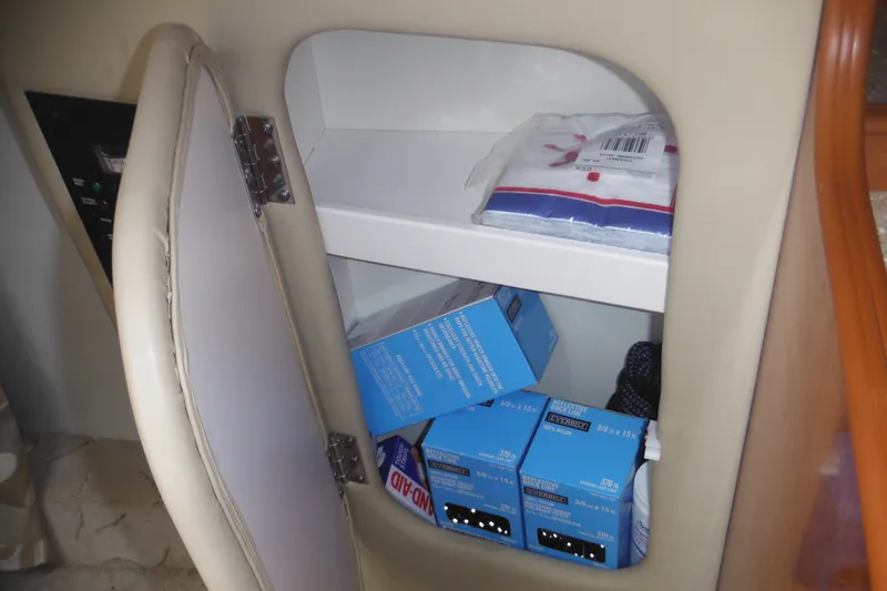 Slide: The Image of Storage compartment in a 2005 Rinker Fiesta Vee 250 boat with supplies and boxes. - 35