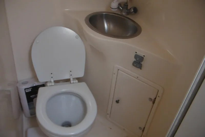 Slide: The Image of 2005 Rinker Fiesta Vee 250 boat bathroom with toilet and stainless steel sink. - 44