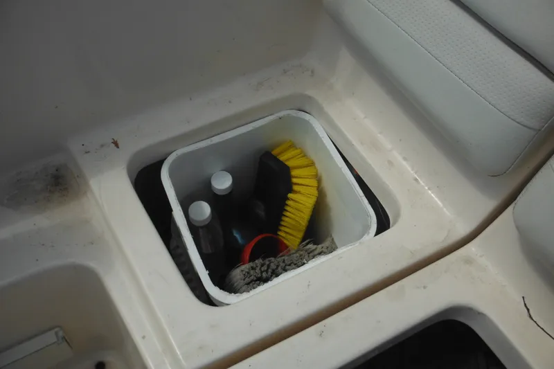 Slide: The Image of Storage compartment on 2005 Rinker Fiesta Vee 250 boat with cleaning supplies and brush. - 53