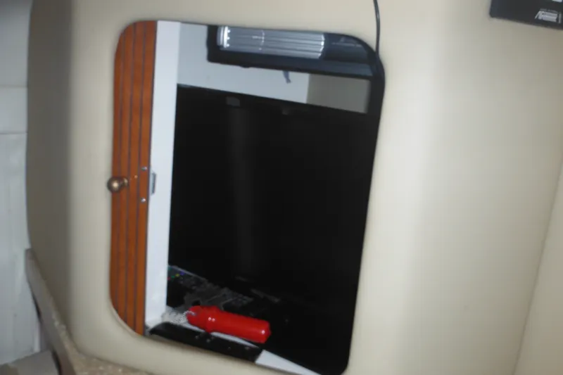 Slide: The Image of Interior of 2005 Rinker Fiesta Vee 250 with storage compartment and red flashlight. - 39