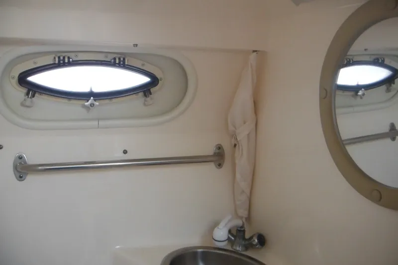 Slide: The Image of 2005 Rinker Fiesta Vee 250 bathroom interior with porthole, mirror, and sink. - 45