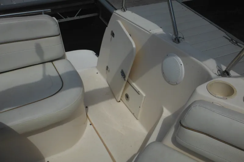 Slide: The Image of 2005 Rinker Fiesta Vee 250 boat interior with white seating and speaker. - 50