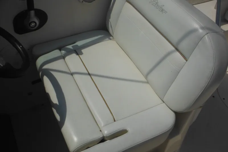 Slide: The Image of 2005 Rinker Fiesta Vee 250 boat seat, white leather upholstery, steering wheel visible. - 21