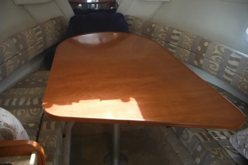 Slide: The Image of Interior of 2005 Rinker Fiesta Vee 250 boat with wooden table and patterned seating. - 30