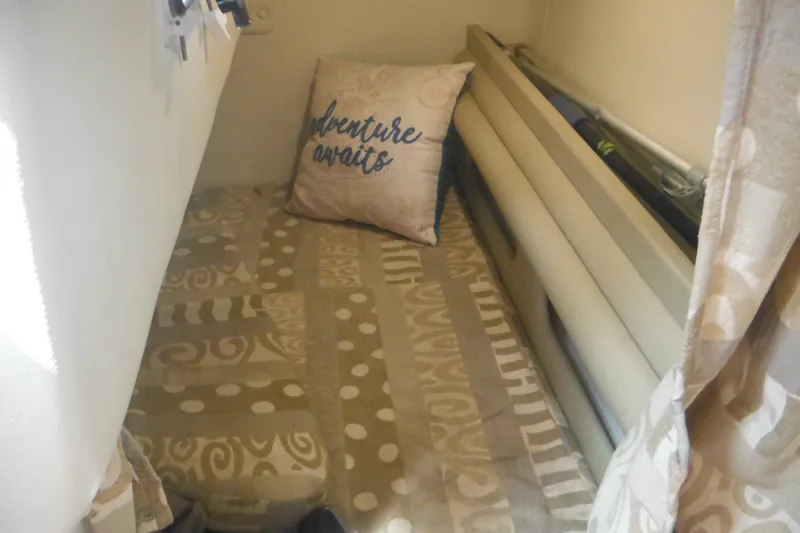 Slide: The Image of Cozy cabin interior of 2005 Rinker Fiesta Vee 250 with patterned bedding and decorative pillow. - 33