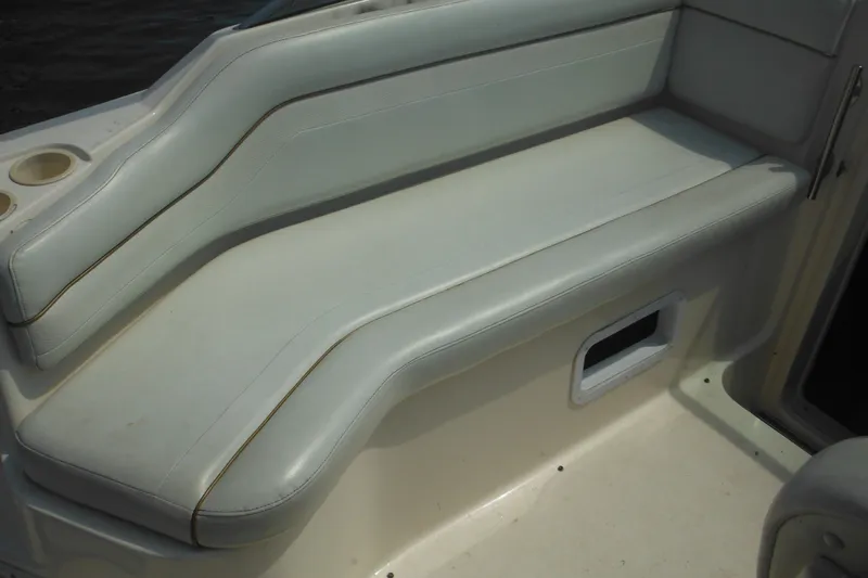 Slide: The Image of 2005 Rinker Fiesta Vee 250 boat seating area with white upholstery and cup holders. - 18