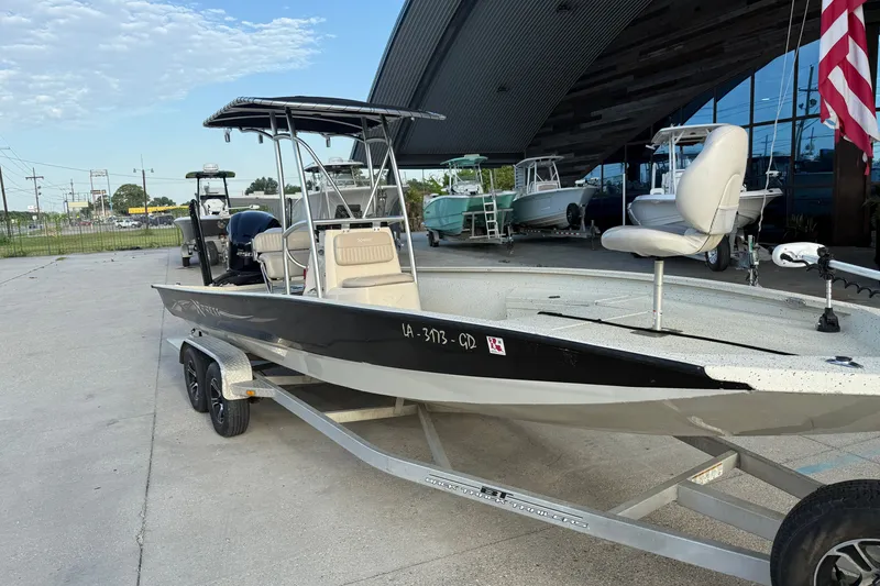 Slide: The Image of A 2015 Xpress H24 Bay boat on a trailer in front of a modern building. - 23