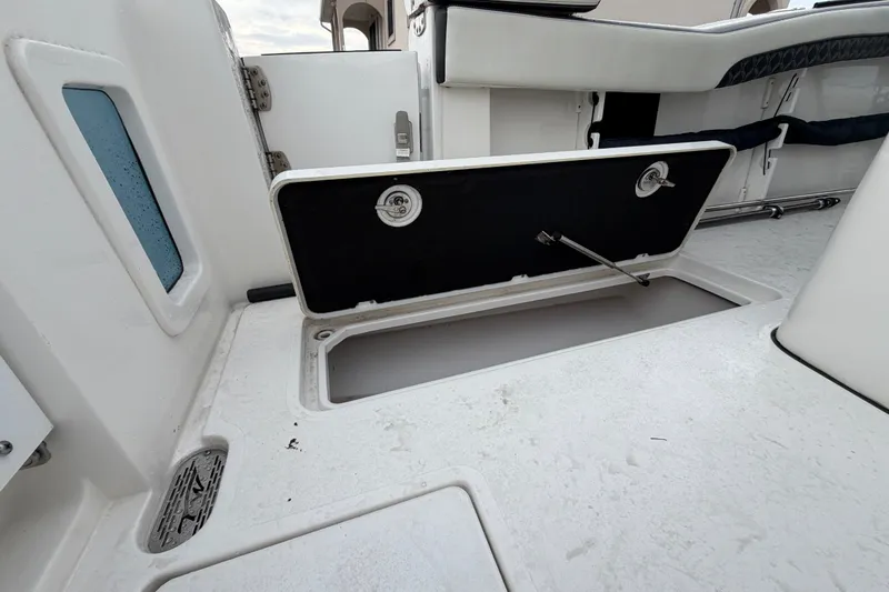 Slide: The Image of 2023 Tidewater 282 CC Adventure Bluewater boat storage compartment open on deck. - 25