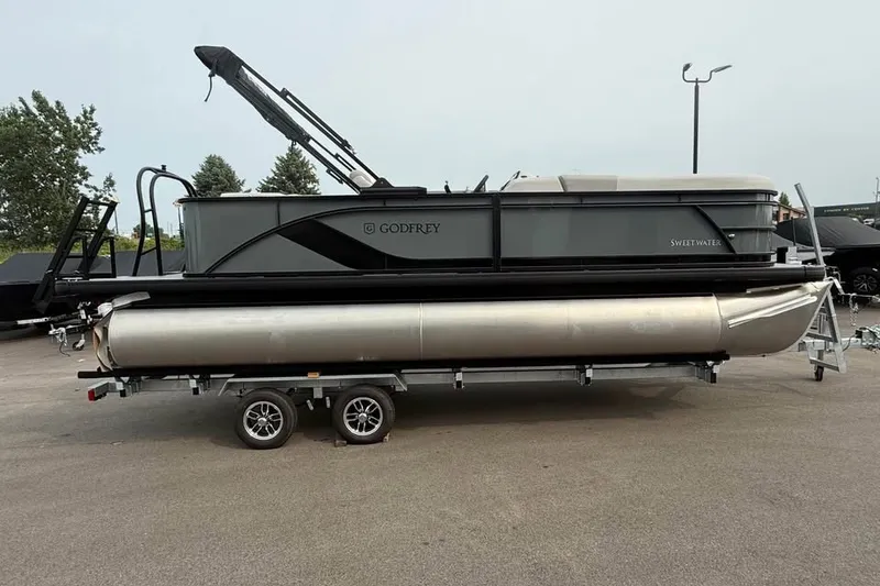 The Image of 2027 Godfrey Sweetwater 2086 C pontoon boat on trailer, parked outdoors. - 0