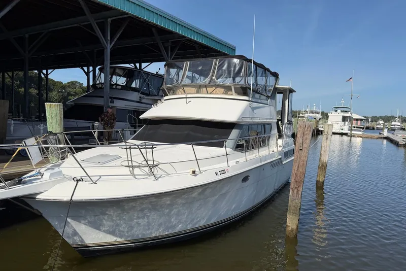 The Image of 1996 Carver 370 Aft Cabin Motor Yacht docked at marina under blue sky. - 0