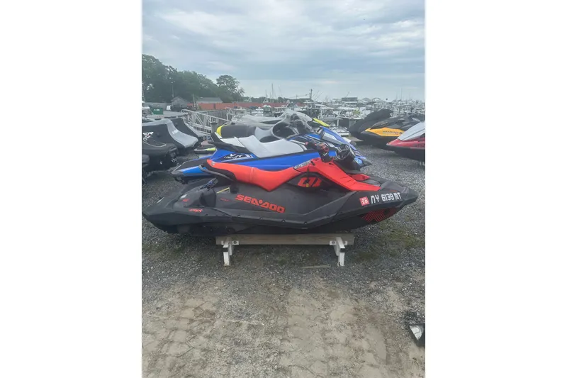 Slide: The Image of 2022 Sea-Doo Spark Trixx jet ski in a marina setting, parked on gravel. - 10