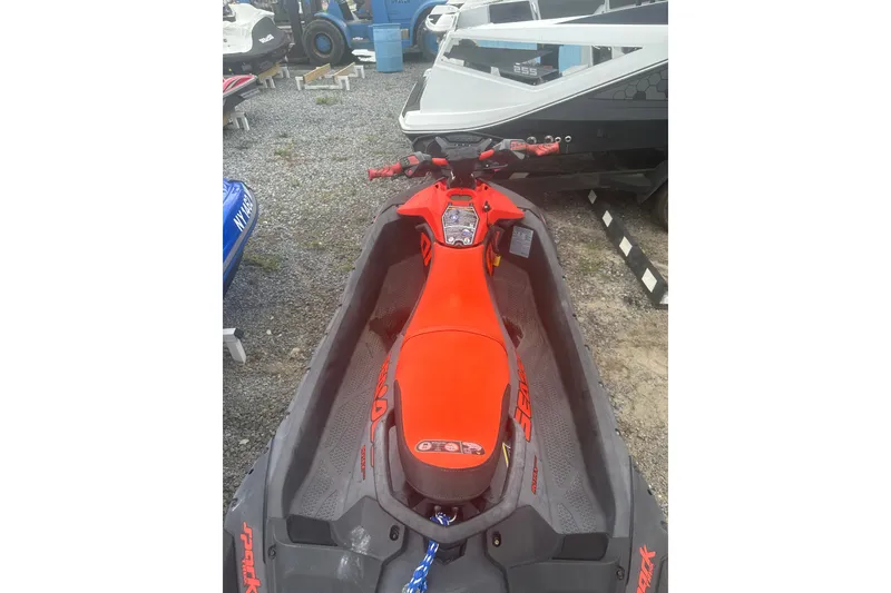 Slide: The Image of 2022 Sea-Doo Spark Trixx in vibrant red, parked on gravel. - 3